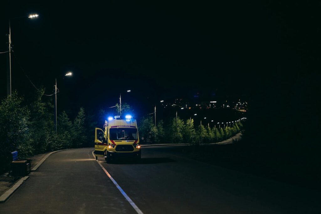 pexels photo 28123710 Ambulance with flashing lights on a rural road at night, ready for emergency response.