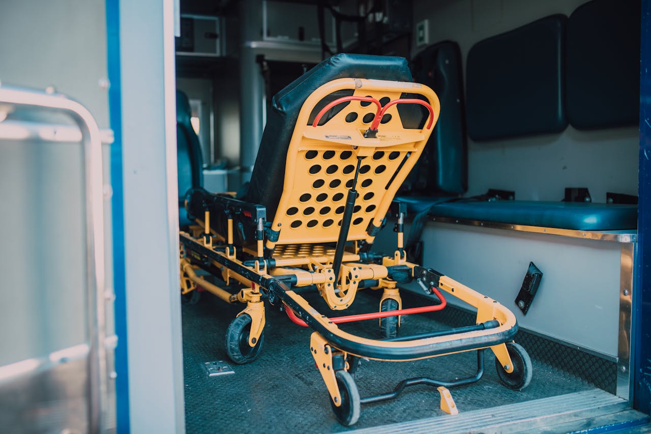 A detailed view of a yellow emergency stretcher inside an ambulance, ready for use.